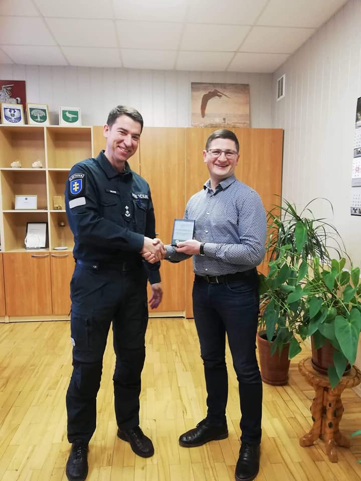 Teisiamas E.Mončauskas gauna apdovanojimą iš policijos komisaro Lino Valiaus rankų.
